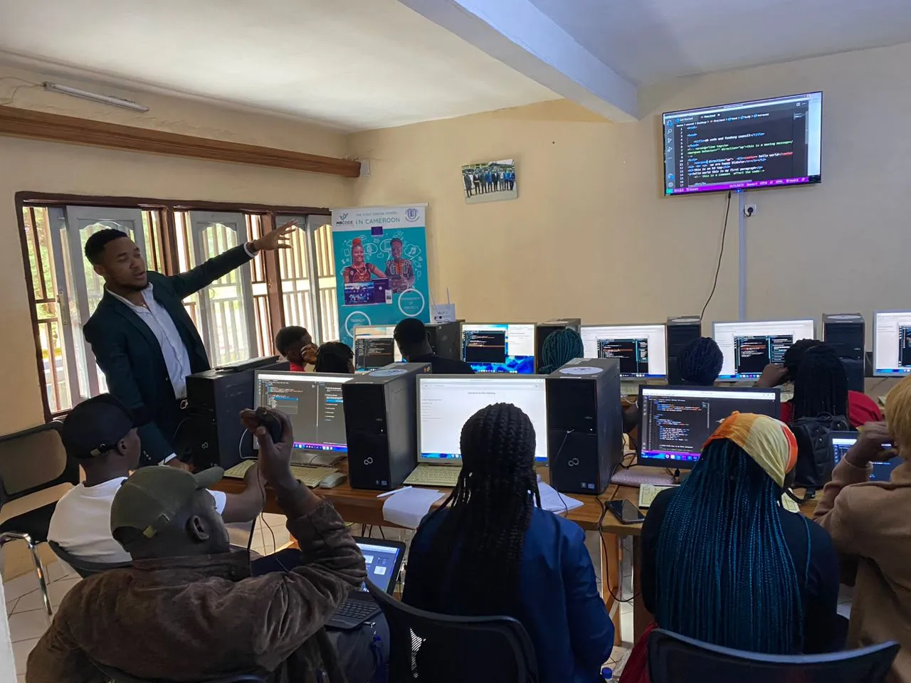 Nsom Emmanuel teaching a room of trainees at computers